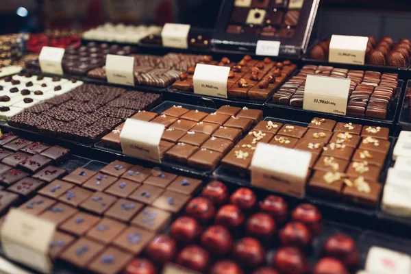 Kafe Vitrininde Çeşitli Sütlü Çikolatalı Tatlılar Dükkanda Değişik Aromalı Fındıklı — Stok fotoğraf