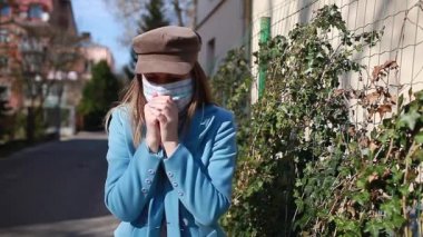 Öksüren kadın Coronavirus covid-19 salgını sırasında dışarıda yürürken tekrar kullanılabilir maske takıyor. Grip salgılayan bir kız. Dikkatli olun, uzak durun.