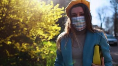 Coronavirus covid-19 salgını sırasında kadın dışarıda yeniden kullanılabilir el yapımı maske takıyor. Boş sokakta tek başına yürüyen bir kız. Kendine dikkat et. Bahar modası