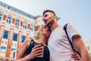 Şehre gelen karışık ırk çifti. Arap adam ve beyaz kadın kahve içiyor Yazlık sokakta sarılıyorlar