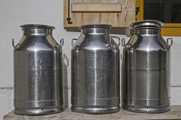 Milk cans in front of the mountain hut — Stock Photo, Image