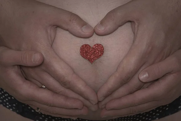 Baby buik met handen — Stockfoto