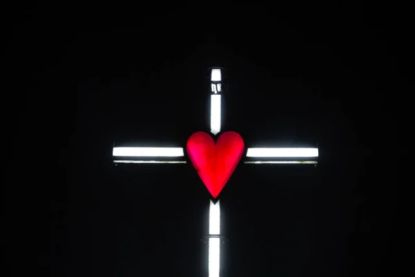 Iluminación de una cruz con corazón rojo — Foto de Stock
