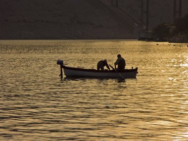 Arka ışıkta balıkçı teknesi