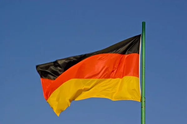 Germania bandiera davanti al cielo nuvoloso blu — Foto Stock