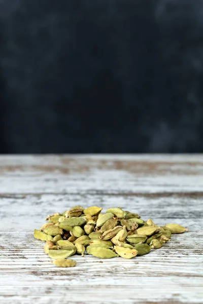 Dry cardamom seeds on white table — Stock Photo, Image