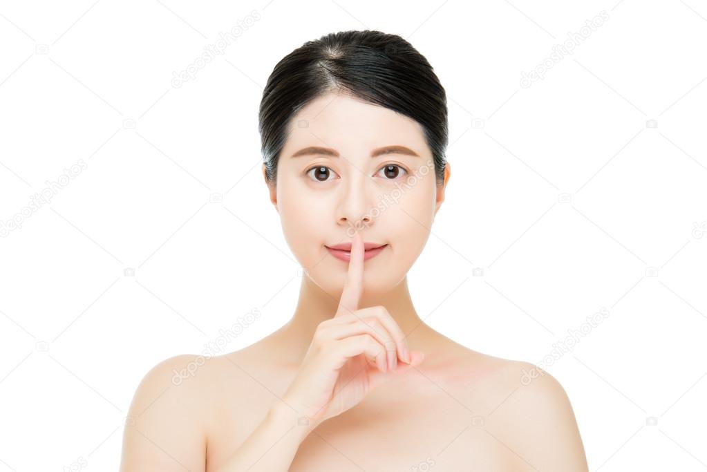 Beautiful woman making a shushing gesture finger to her lips