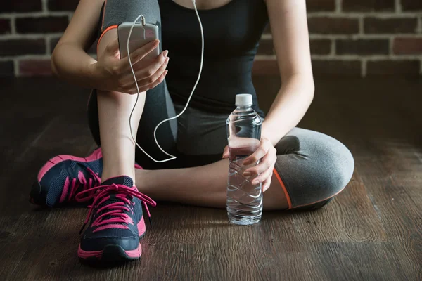 Odpocząć, słuchając muzyki wody pitnej po wagę fitness — Zdjęcie stockowe