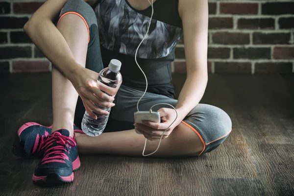 Descansar ouvindo música beber água após exercício de fitness — Fotografia de Stock