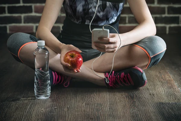 Neem rust luisteren naar muziek drinkwater eten apple — Stockfoto