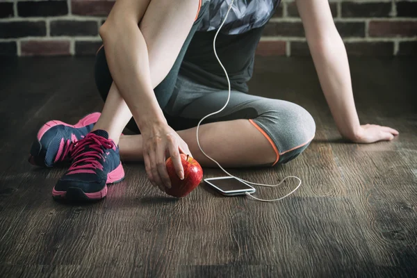 Riposa ascoltando la musica mangiare mela dopo l'esercizio di fitness — Foto Stock