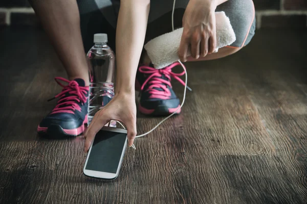 Pegar telefone inteligente ouvir música, treinamento de exercícios de fitness — Fotografia de Stock