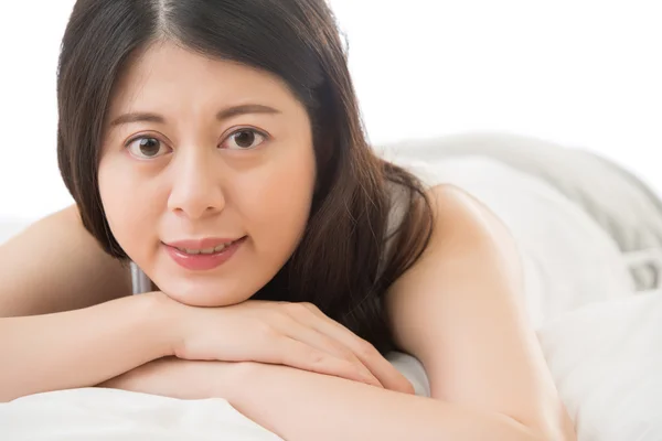 美しいアジアの女性がカメラに顔を笑顔、ベッドに横たわる — ストック写真