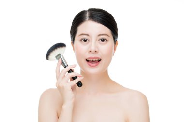 güzel Asya model yüzünde makyaj Vakfı fırça ile uygulayın