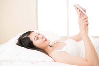 mutlu kadın yatakta dijital tablet cihaz ile okuma