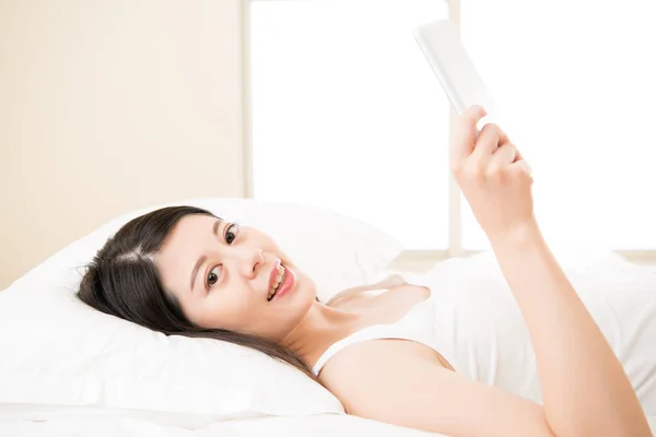 Mujer feliz lectura con dispositivo de tableta digital en la cama — Foto de Stock