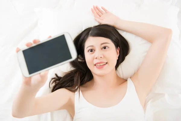 Hermosa mujer asiática tomar selfie con smartphone en la cama — Foto de Stock