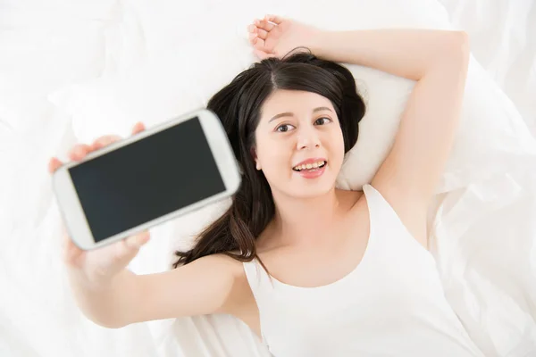 Hermosa mujer asiática tomar selfie con smartphone en la cama — Foto de Stock