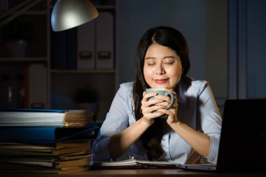 asian business woman drink coffee working overtime late night clipart