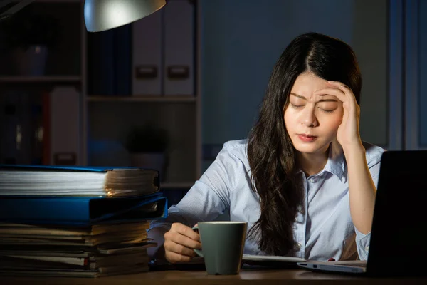 Asiático negocios mujer beber café dolor de cabeza horas extras trabajo tarde —  Fotos de Stock