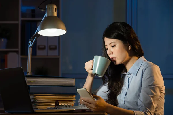 Asiático mulher de negócios falar no smartphone trabalhando horas extras — Fotografia de Stock