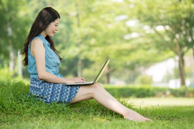 park açık bilgisayar kullanan güzel Asyalı kadın