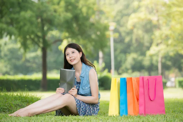 Mujer asiática usando tableta digital pensando compras en línea —  Fotos de Stock