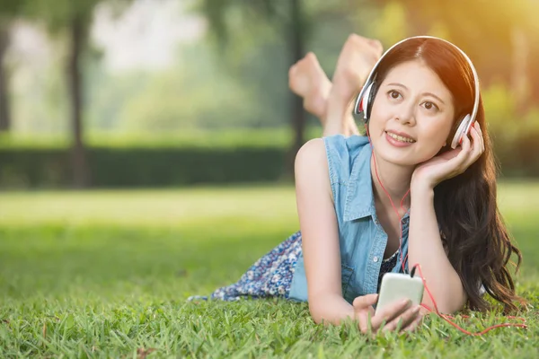 Mooie Aziatische vrouw luisteren muziek met slimme telefoon — Stockfoto