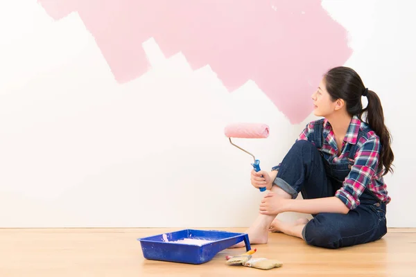 Mujer pintando la pared interior de la casa nueva — Foto de Stock