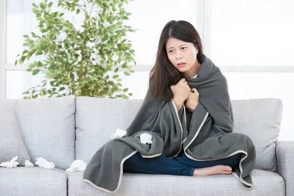 Woman feeling cold sitting on sofa — Stock Photo, Image