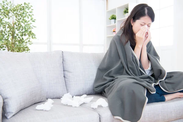 Mujer joven enferma estornuda en casa — Foto de Stock