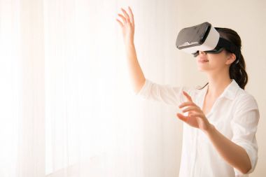 VR kulaklıklı kadın yukarı bakıyor.