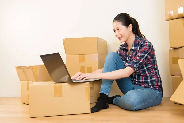 Женщина, работающая онлайн во время переезда — стоковое фото
