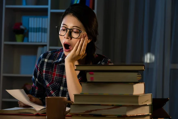 Joven estudiante bostezando por la noche con libros — Foto de Stock