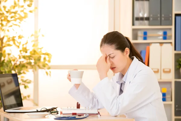 Médico cansado en el consultorio bebiendo café — Foto de Stock