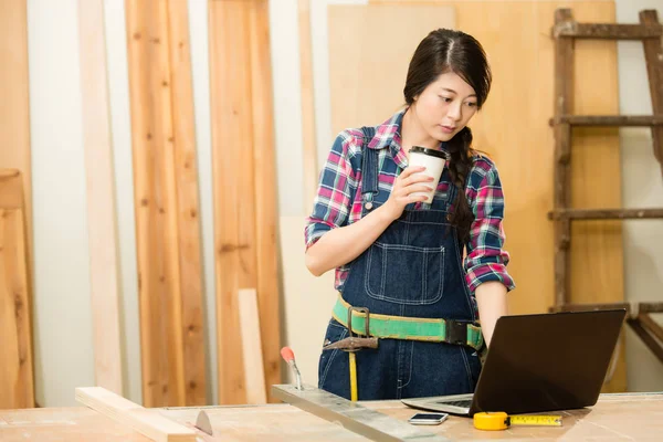 Chinarsi al banco da lavoro per digitare sul computer portatile — Foto Stock