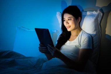 Geceleri yatağında tablet pc kullanan kız