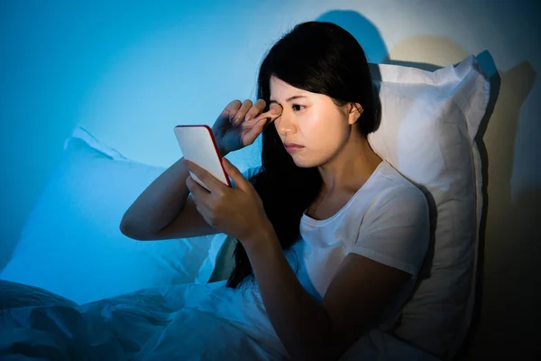 Mujer frotando los ojos con el uso de smartphone — Foto de Stock