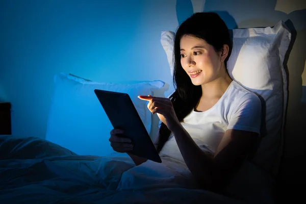 Mujer usando tableta digital y sentada en la cama — Foto de Stock