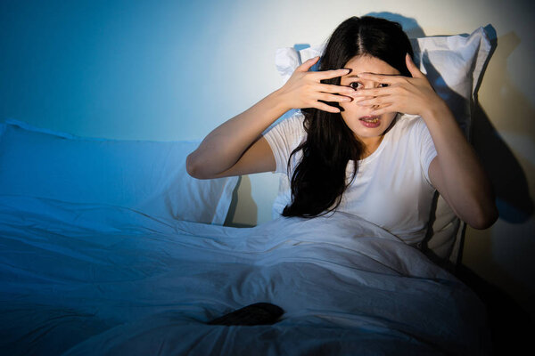 девочка, смотрящая фильм ужасов, закрыла глаза
