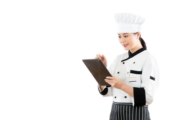 Lachende Aziatische vrouw chef-kok met behulp van digitale tablet — Stockfoto