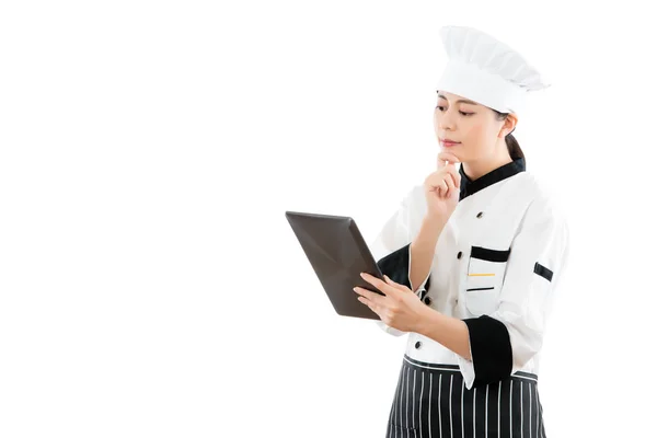 Chef looking at digital pad and thinking — Stock Photo, Image