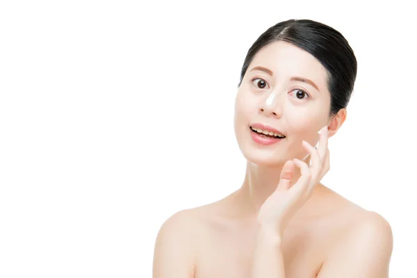 Modèle appliquant un traitement à la crème sur son visage — Photo