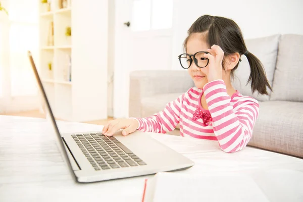 Дівчина в великих окулярах використовує свій ноутбук — стокове фото