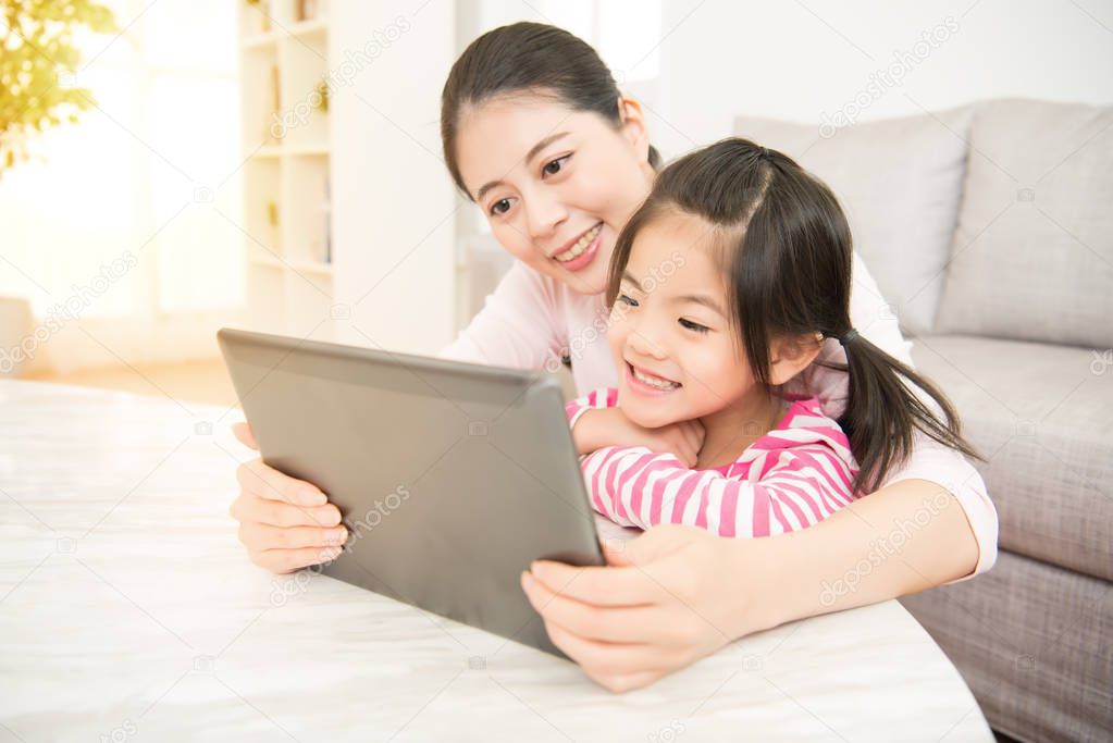 woman and her little daughter using pad