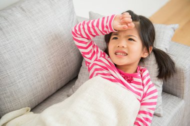 Ateş ile kanepede uzanmış kız hasta çocuk