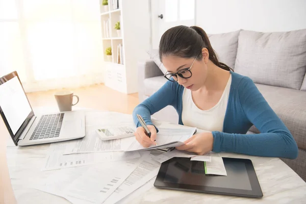 Vrouw met behulp van laptop aan en het stootkussen voor het berekenen van de rekeningen — Stockfoto