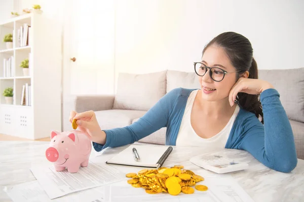 Woman deposit gold coin into piggy bank — Stock Photo, Image