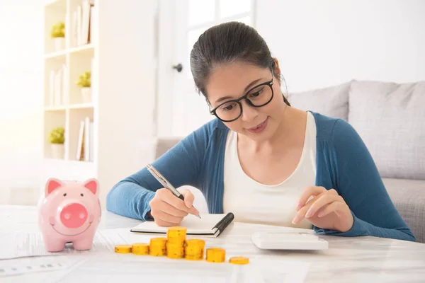 Mujer contando sus ahorros de torre de dinero — Foto de Stock