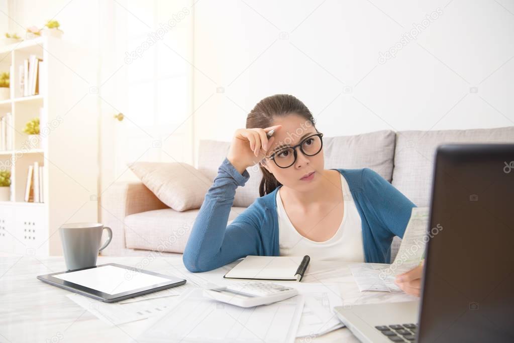 worried asian housewife using a laptop